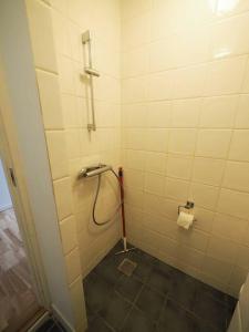 ein Bad mit einer Dusche und einem WC-Papierspender in der Unterkunft Simple & cosy flat -2 minutes to Nuuks Plads metro in Kopenhagen