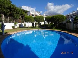 una gran piscina azul en un patio en Nerja - Casa Vivi 8, en Nerja