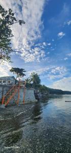 a view of a river with a wooden bridge at Chue&larry's Beachside Homestay in Libagon