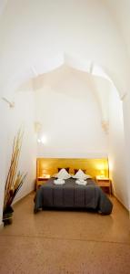 een slaapkamer met een bed in een witte kamer bij Casina Raho B&B in Nardò