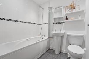 a white bathroom with a toilet and a sink at Tincroft Cottage - high end, luxury living near the beach in Truro +13 photos