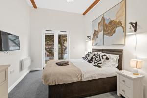 a bedroom with a bed and a television in it at Tincroft Cottage - high end, luxury living near the beach in Truro