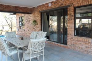 a patio with a table and chairs on a brick wall at Sonop in Marloth Park in Marloth Park