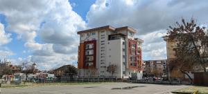 a tall white and red building with a parking lot at Luxury apartment Private parking self check-in51 in Craiova