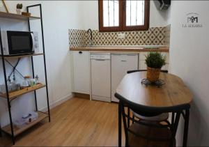 cocina con mesa de madera y mesa pequeña con sillas en La Alkarra, en Alcalá del Júcar