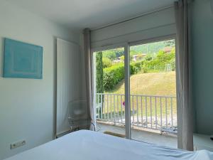 a bedroom with a bed and a view of a balcony at Pause Detente Sur La Port Du Bourget Du Lac in Le Bourget-du-Lac