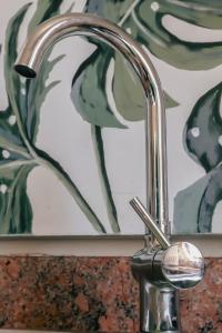 a chrome bathroom sink faucet in front of a mirror at Ocean Rocks Villa, Umhlanga in Durban