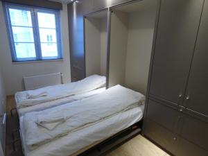 um pequeno quarto com uma cama e um espelho em Edward Hopper Suite, Duinhof 3-9-7, spacious apartment near the beach with sunny balcony em Cadzand