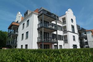 um grande edifício branco com varandas em Edward Hopper Suite, Duinhof 3-9-7, spacious apartment near the beach with sunny balcony em Cadzand