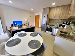 cocina y sala de estar con mesa blanca y sillas en Casa do Rio, en Ponte da Barca