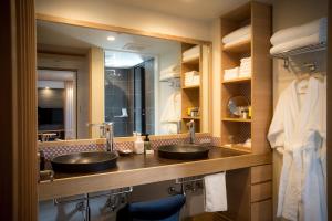 een badkamer met 2 wastafels en een grote spiegel bij Sakaeya in Yamanouchi