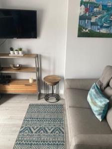 a living room with a couch and a table at Luxury Mumbles View Studio Apartment in Swansea