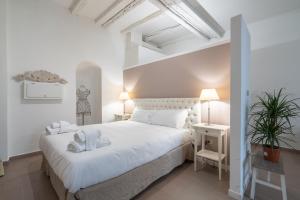 a bedroom with a white bed and a plant at Casa Bacìomari in Bologna