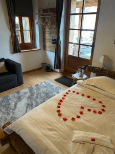 Una cama con un montón de rosas rojas. en Les chambres et Roulottes des Noisetiers en Leysin