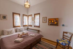 a bedroom with a bed and a chair and windows at Villa Stefanos in Katochori