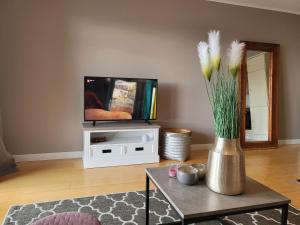 圣彼得奥尔丁Ferienwohnung Deichglück - Direkt am Böhler Sandstrand的客厅,带花瓶的桌子