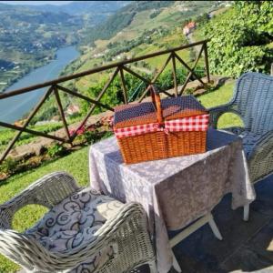 a table with two chairs and a basket on it at Casa De Canilhas in Mesão Frio