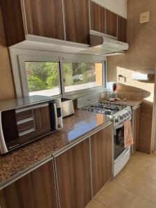 una cocina con estufa y microondas en Departamento Caseros, en Salta