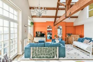 a living room with orange walls and a blue couch at Dovecote - sanctuary in the sky in London