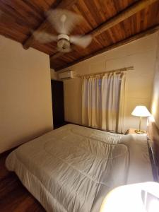 Schlafzimmer mit einem Bett mit Holzdecke in der Unterkunft Pindó I in Concordia