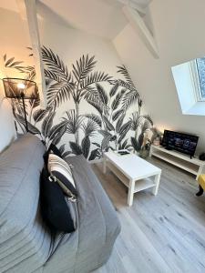 L'ENSOLEILLÉ - Classé 2 étoiles - Nay centre - Appartement في Nay: غرفة معيشة مع أريكة وجدار نباتي