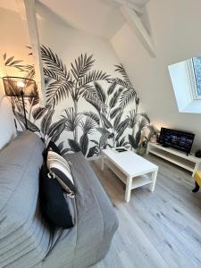 a living room with a couch and a plant wall at L'ENSOLEILLÉ - Classé 2 étoiles - Nay centre - Appartement in Nay