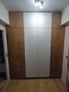 a large closet with white doors and wooden walls at Underground Apartament in Łomża