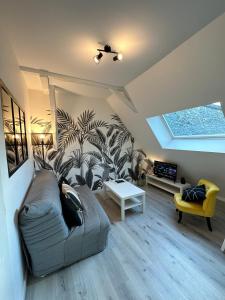 a living room with a couch and a table at L'ENSOLEILLÉ - Classé 2 étoiles - Nay centre - Appartement in Nay