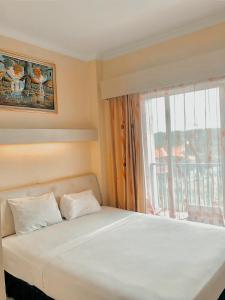 a bed in a room with a large window at Permata Inn Slawi in Procot
