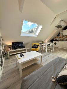 L'ENSOLEILLÉ - Classé 2 étoiles - Nay centre - Appartement في Nay: غرفة معيشة مع أريكة وطاولة