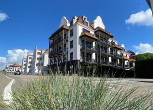 a large apartment building on the side of a street at Caramia, Duinhof 5-1-14, Romantic apartment by the sea in Cadzand-Bad