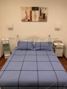 - un lit avec une couette bleue dans une chambre dans l'établissement A de Maria - Tres Marias Apartments, à Redondela