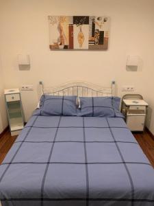 łóżko z niebieską kołdrą w sypialni w obiekcie A de Maria - Tres Marias Apartments w mieście Redondela