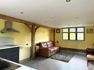 een woonkamer met een leren bank in een keuken bij Forest Apartment gated Parking on 2 acres Garden in Chislehurst