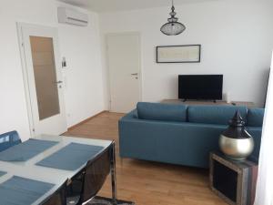 ein Wohnzimmer mit einem blauen Sofa und einem Tisch in der Unterkunft Vienna Belvedere und Hauptbahnhof Apartment in Wien