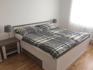 a bed with a black and white comforter in a bedroom at Vienna Belvedere und Hauptbahnhof Apartment in Vienna