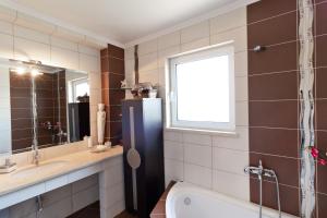 a bathroom with a sink and a toilet and a window at El-Ni-Noe in Chorafakia +17 photos