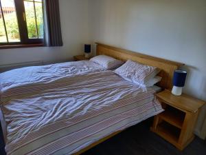 a large bed in a bedroom with a night stand at Holiday Home Schwabenhaus in Kirkcaldy