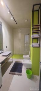 een badkamer met 2 toiletten en een groene muur bij Residence La Pineta in Golem