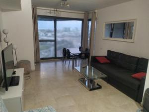 a living room with a black couch and a table at Marina vaction rentals in Herzliyya B