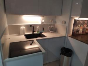 una pequeña cocina con fregadero y lámpara en Marina vaction rentals en Herzliyya B