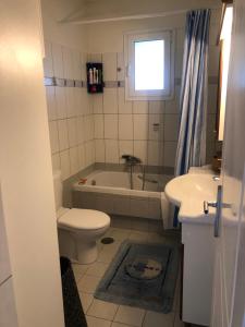 a bathroom with a toilet and a tub and a sink at Villa Sophia in Porto Rafti