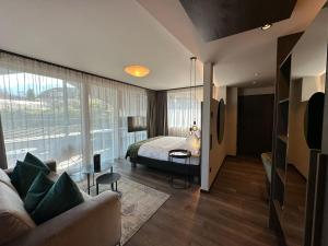 una camera con un letto e una grande finestra di Appius Design Suites B&B - ADULTS ONLY ad Appiano sulla Strada del Vino