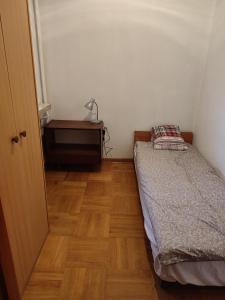 a small bedroom with a bed and a desk at Warszawska 
