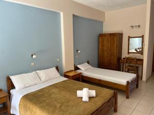 a hotel room with two beds and a mirror at Mediterranean Sea Down Floor in Palaiochóra