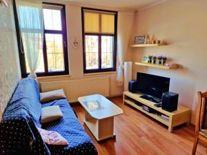 a living room with a couch and a tv at Plac Słowiański - Sweet House in Świnoujście