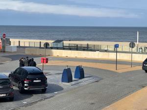 a group of people standing in a parking lot near the beach at Sunny Seaview in Ostend