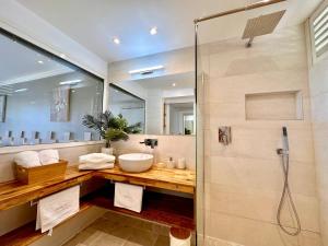 La salle de bains est pourvue d'un lavabo et d'une douche. dans l'établissement Curaçao 13 studio vue mer proche plage dans Complexe type Village Vacances, à Sainte-Luce