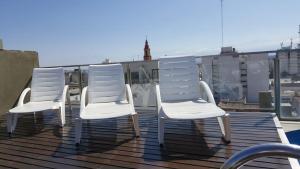 three white chairs sitting on top of a roof at Departamento Caseros in Salta