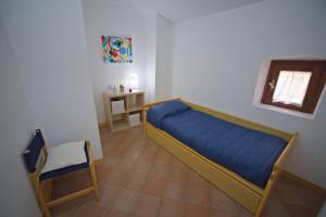 ein Schlafzimmer mit einem blauen Bett und einem Stuhl in der Unterkunft Santa Caterina in Brindisi